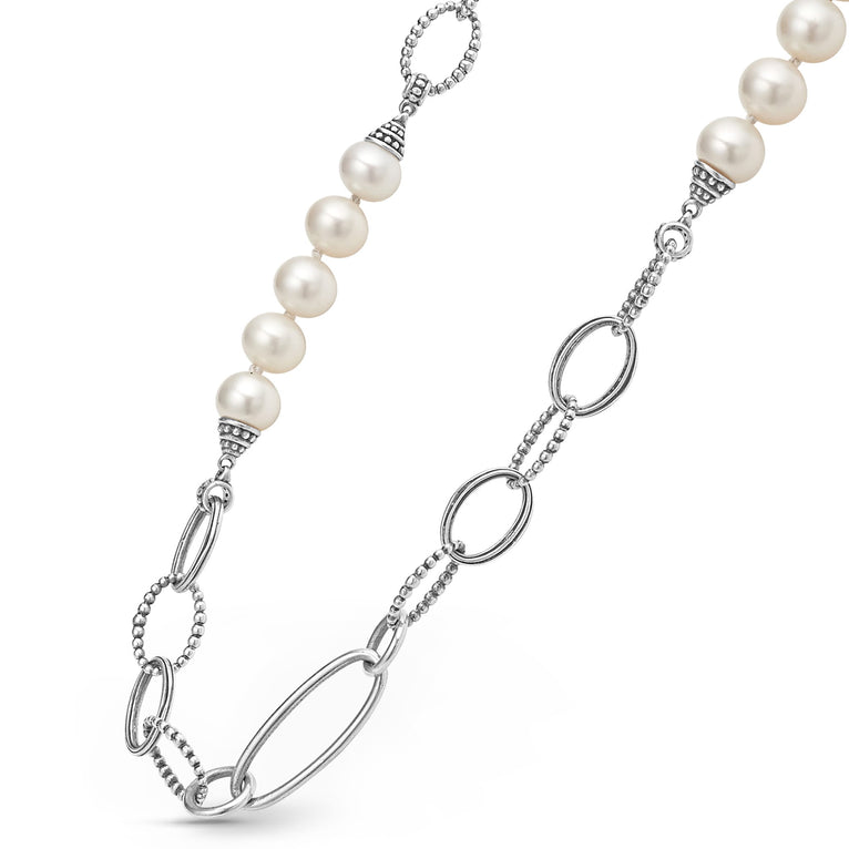 A close-up of a sterling silver & 18k gold necklace angled to the right, featuring a pearl diamond pendant against a white background.