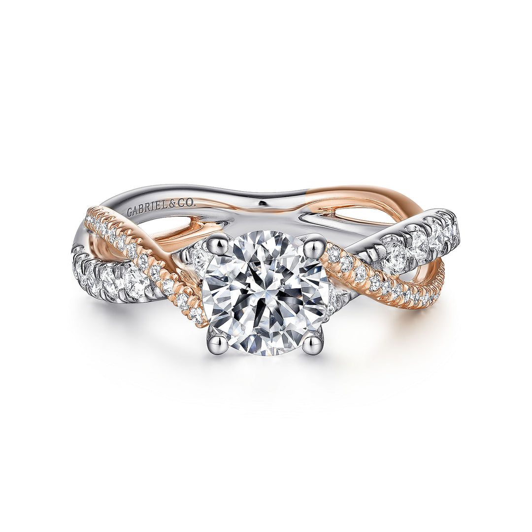 A white and rose-gold ring lies flat against a white background. It features a round-cut diamond set in the center with a twisted design band.