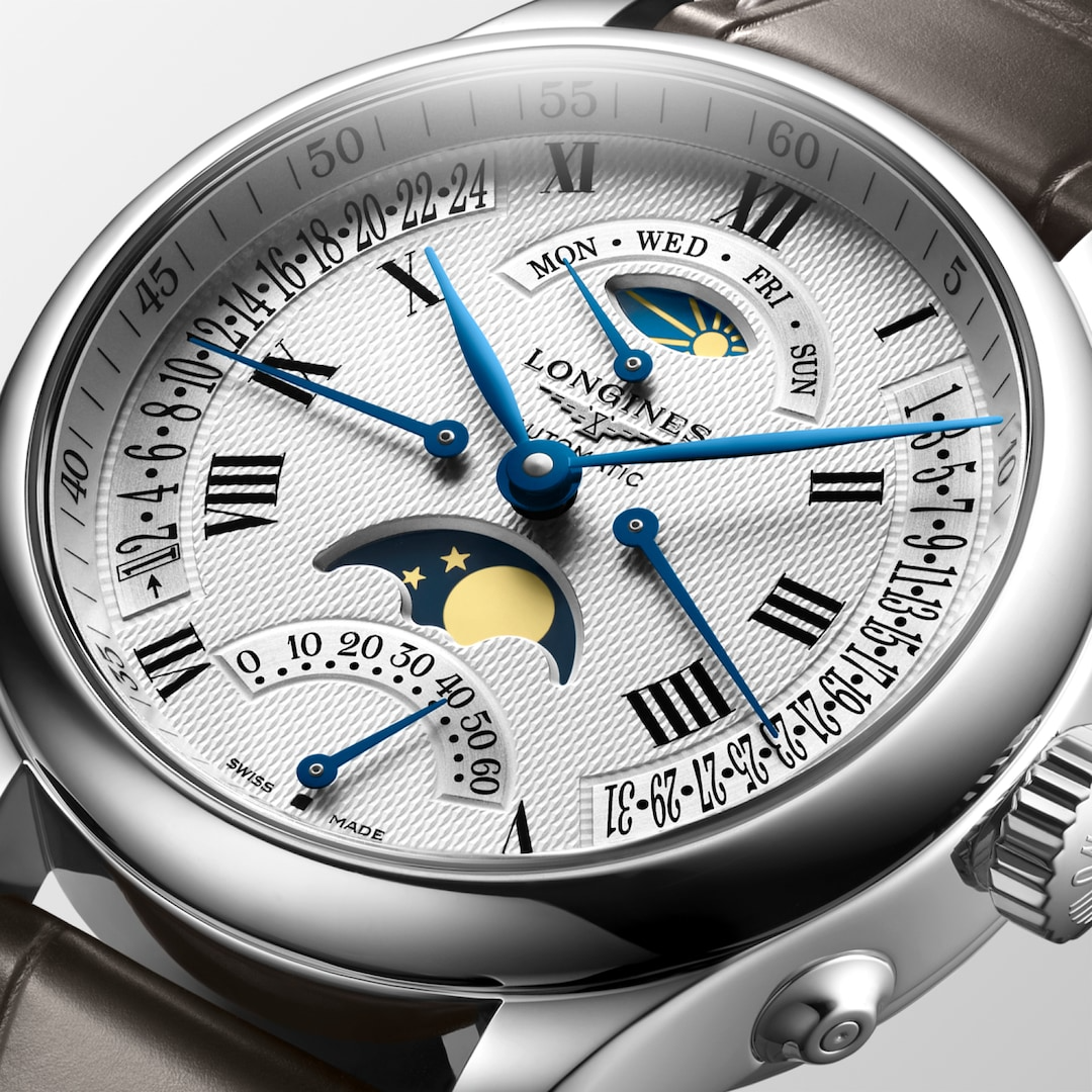 A close-up of a Longines watch highlighting the silver dial and crown. 