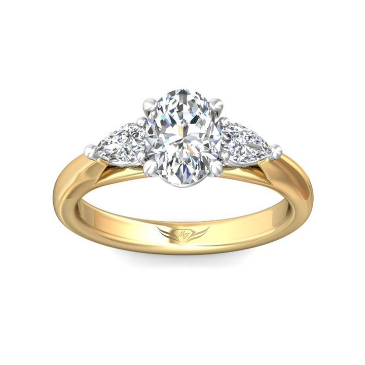 The Pear Side Stones Engagement Ring, made of yellow gold, tilted forward against a white background. It features an oval-cut diamond set in the center with pear-shaped side diamonds. Showing the "Martin Flyer" inscription is visible inside the band.