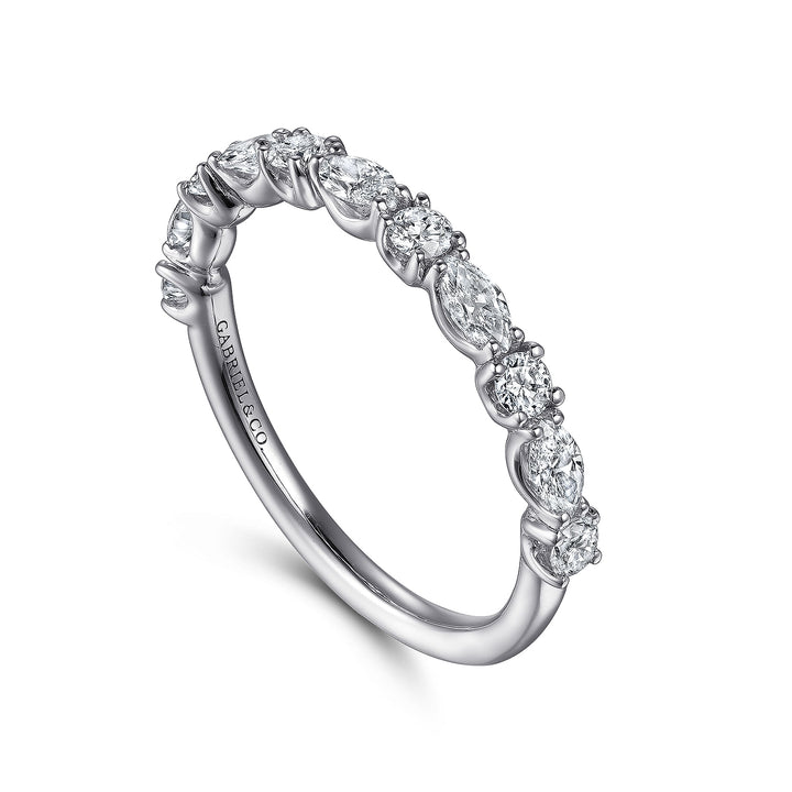 This is a close-up of a white gold ring angled to the right. It shows the inside of the band against a white background. The band features alternating oval and round-cut diamonds in a straight line.