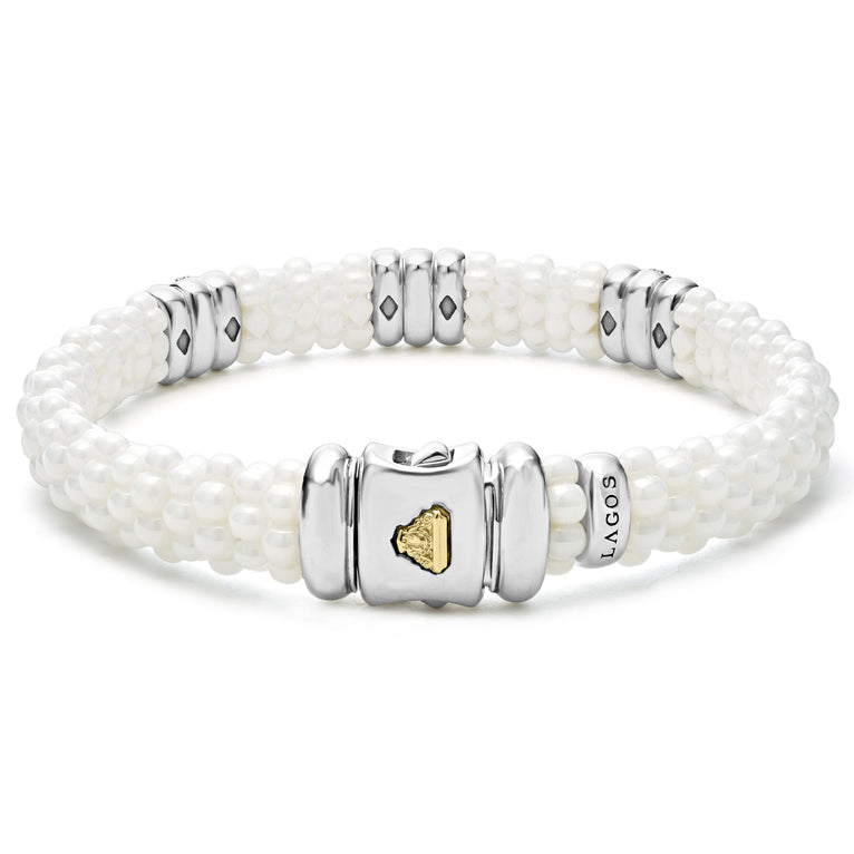 A sterling silver bracelet in the middle of a white background highlight the clasp, featuring three diamond stations, white ceramic caviar beading, and sterling silver stations