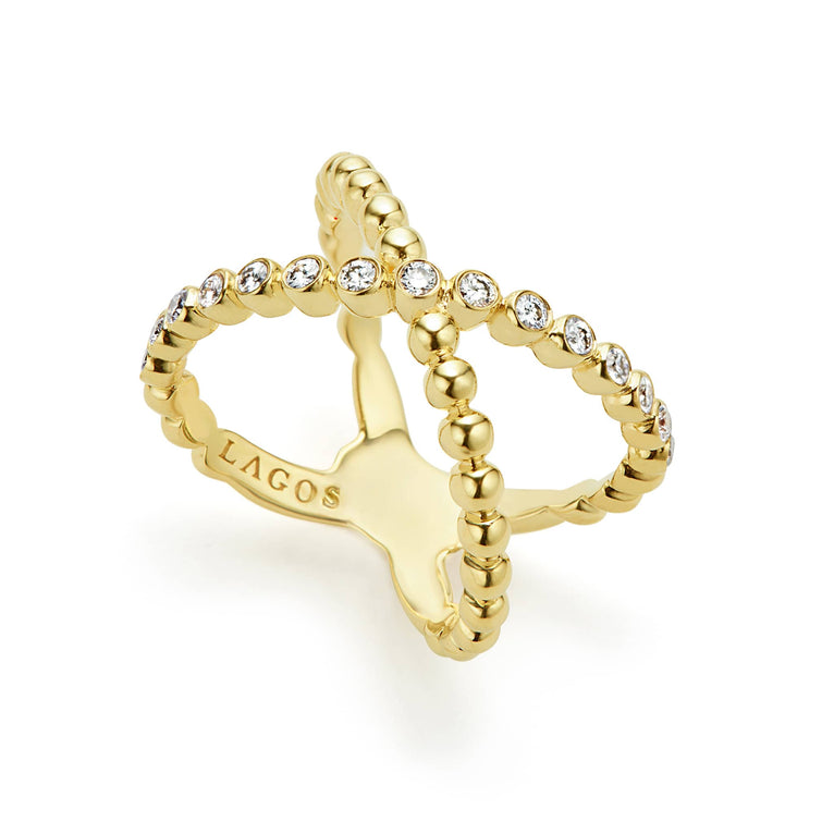 An 18K Gold ring against a white background featuring caviar beading and an X design.