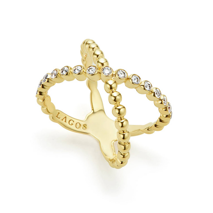 An 18K Gold ring against a white background featuring caviar beading and an X design.