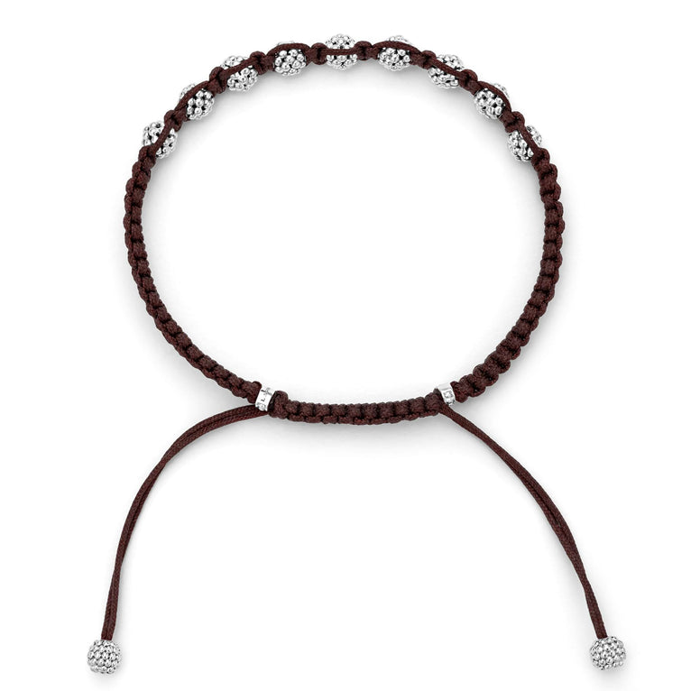 A side-view of a brown bracelet in the middle of the white background featuring a braided nylon with sterling silver Caviar beads.