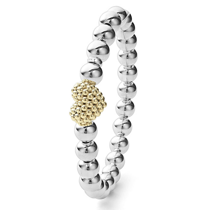 A sterling silver and 18k gold beaded bracelet standing vertically in the middle of a white background featuring an 18k gold and silver Caviar beaded heart accent