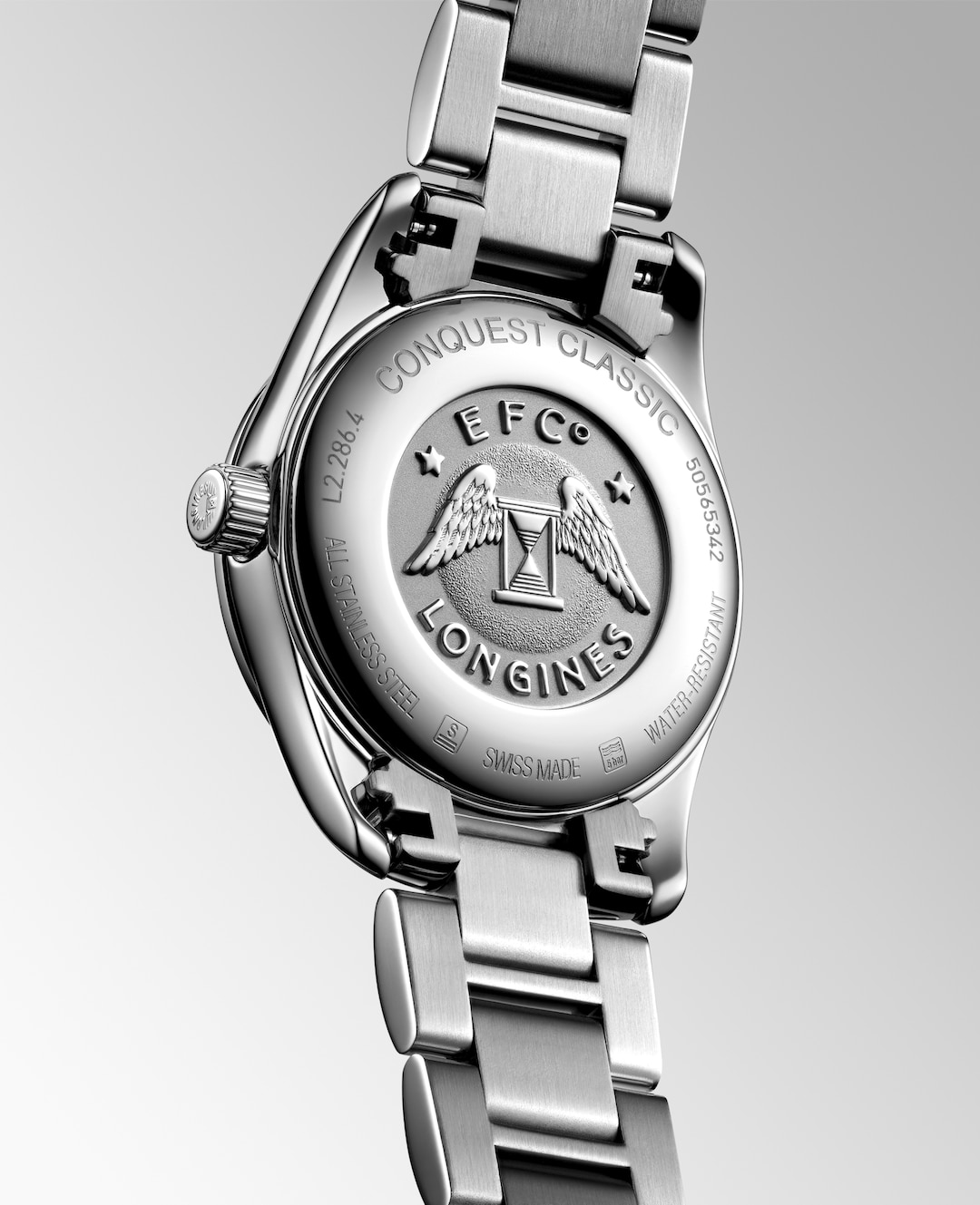 A Longines watch is displayed in the middle, angled to the right, showcasing the back of the dial on a white background. The back of the watch has EFC Longines engraved on the dial and Conquest Classic engraved at the top section of the bezel.