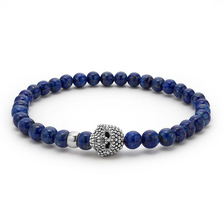 A sterling silver bracelet is displayed in the middle of a white background featuring a Lapis gemstone beaded bracelet with a sterling silver Caviar skull.