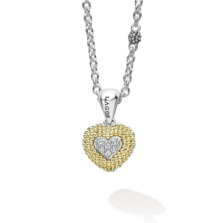 This is a close-up of a sterling silver &18k gold necklace featuring a diamond heart pendant framed by 18K Gold Caviar beading