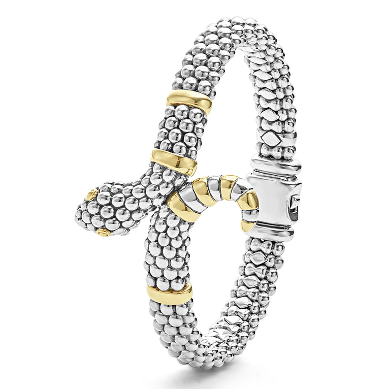 A sterling silver & 18k gold bracelet laid vertically in the middle of a white background featuring a snake motif, gold stations, and sterling silver caviar beading.