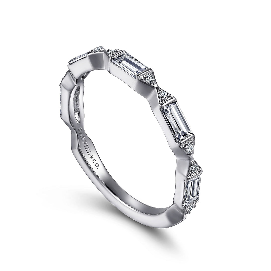 This is a close-up of a white gold ring angled to the right. It shows the inside of the band against a white background. The band features baguette-cut diamonds in stations.