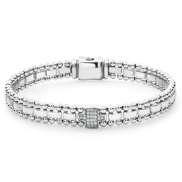 A sterling silver link bracelet in the middle of a white background featuring single pavé diamond station framed by sterling silver Caviar beading