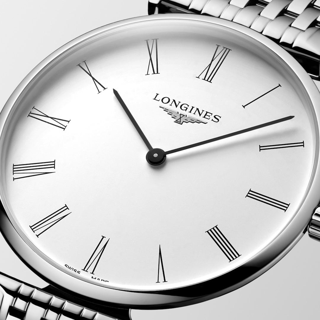 This is a close-up of a Longies watch angled to the right, showcasing the dial with a white background. The watch features a white dial, black hands and markers, a stainless steel bezel, and a stainless steel bracelet.