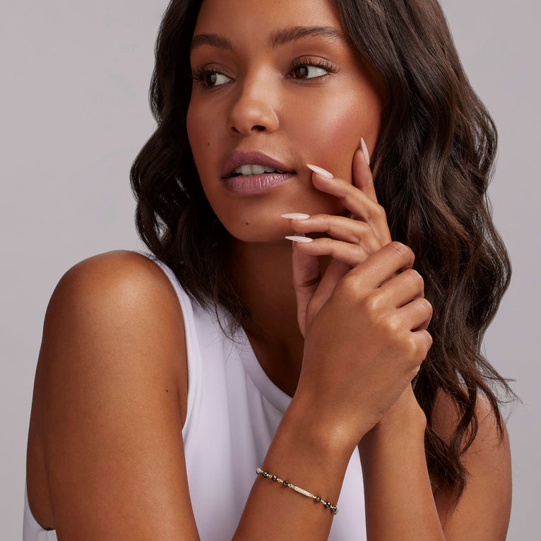 A woman is wearing a Sterling silver bracelet featuring Black ceramic and sterling silver Caviar beads.