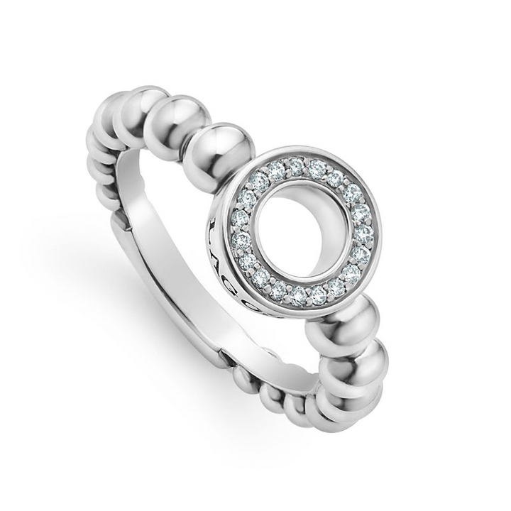 A sterling silver ring is displayed angled on a white background featuring diamond circle detailing the LAGOS logo sits on a tapered Caviar beaded band