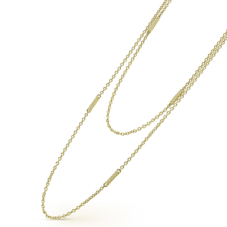 A close-up of an 18k gold necklace angled to the right, featuring caviar beading, stations, and a lobster clasp against a white background.