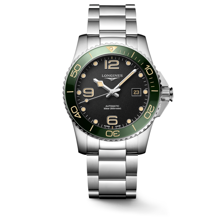 A Longines watch standing straight against a transparent background. The watch features a black dial, white & tan hands and markers, a green bezel, a crown on the right side, and a stainless steel strap.