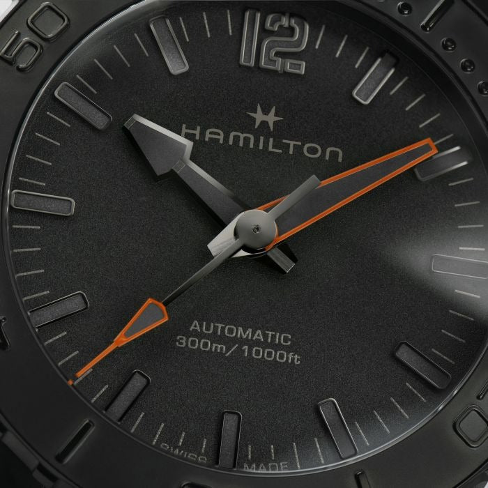 A close-up side-view of a Hamilton watch, focusing on the black dial and PVD black coating steel case.