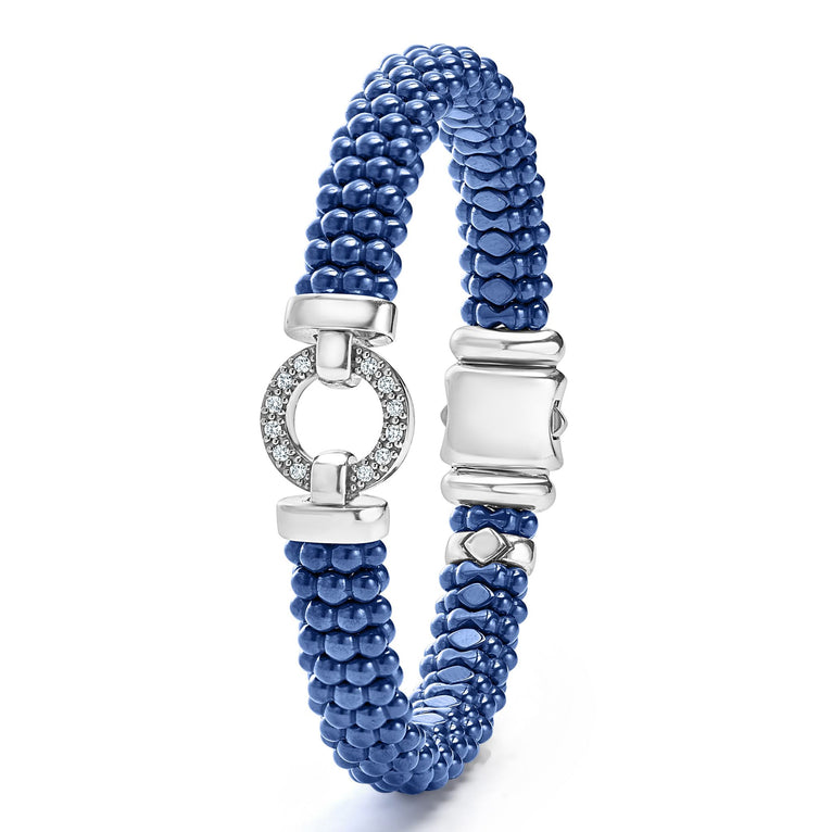 A sterling silver bracelet in the middle vertically of a white background features a diamond circle motif and ultramarine ceramic caviar beading.