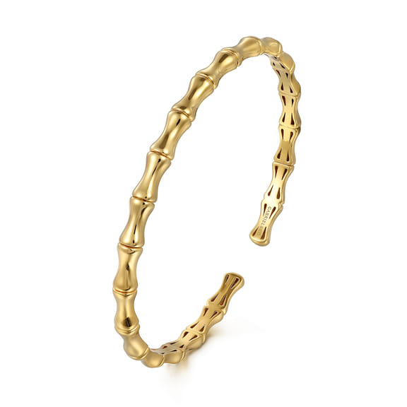 Angled view of the Gabriel & Co gold bar station bangle showing its open ends and pierced inner design