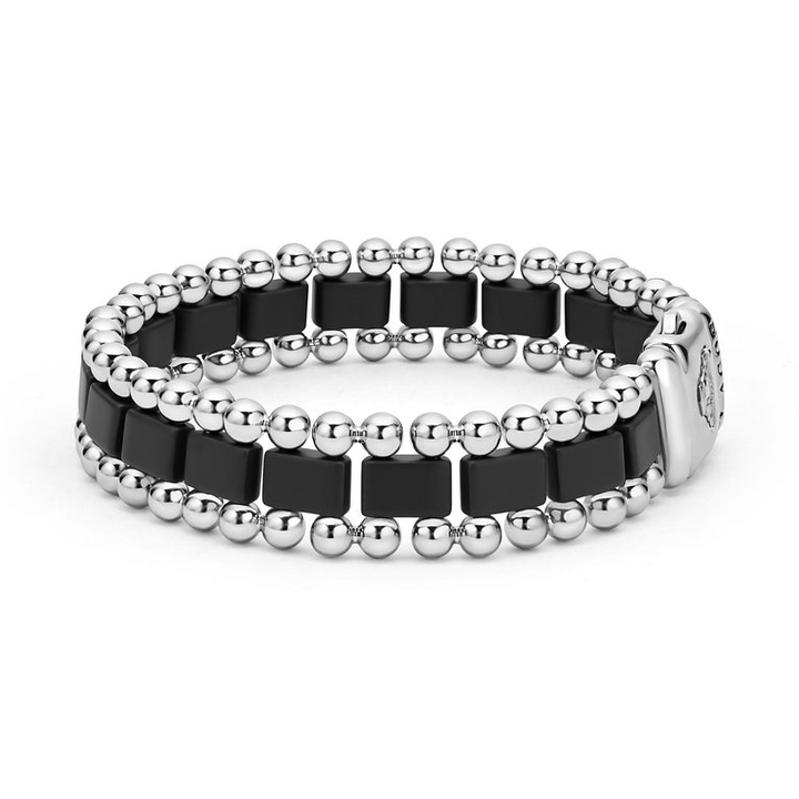 A side-view of a stainless steel bracelet in the middle of a white background featuring matte black ceramic and caviar beading.