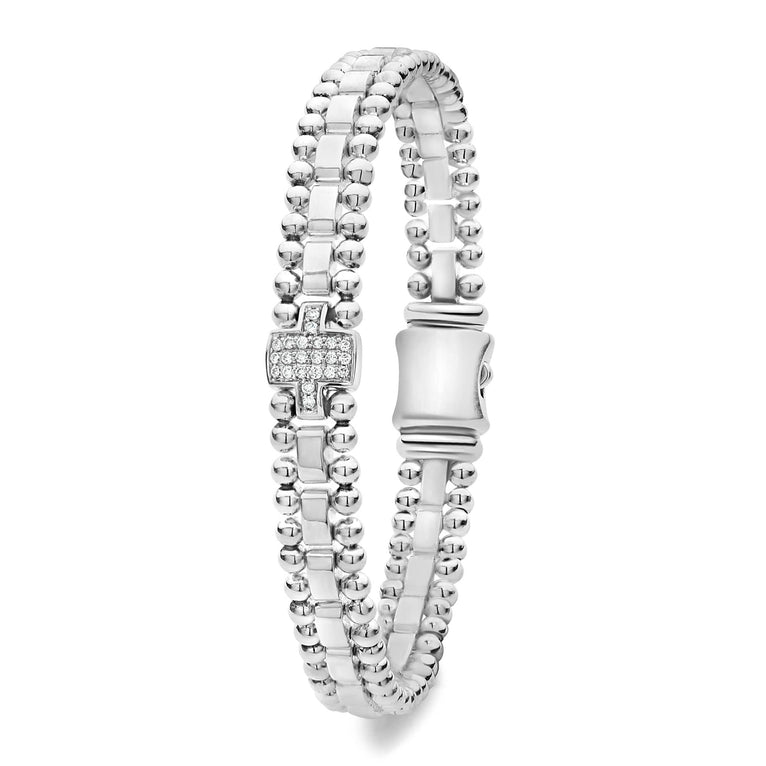 A sterling silver link bracelet angled in the middle of a white background featuring single pavé diamond station framed by sterling silver Caviar beading