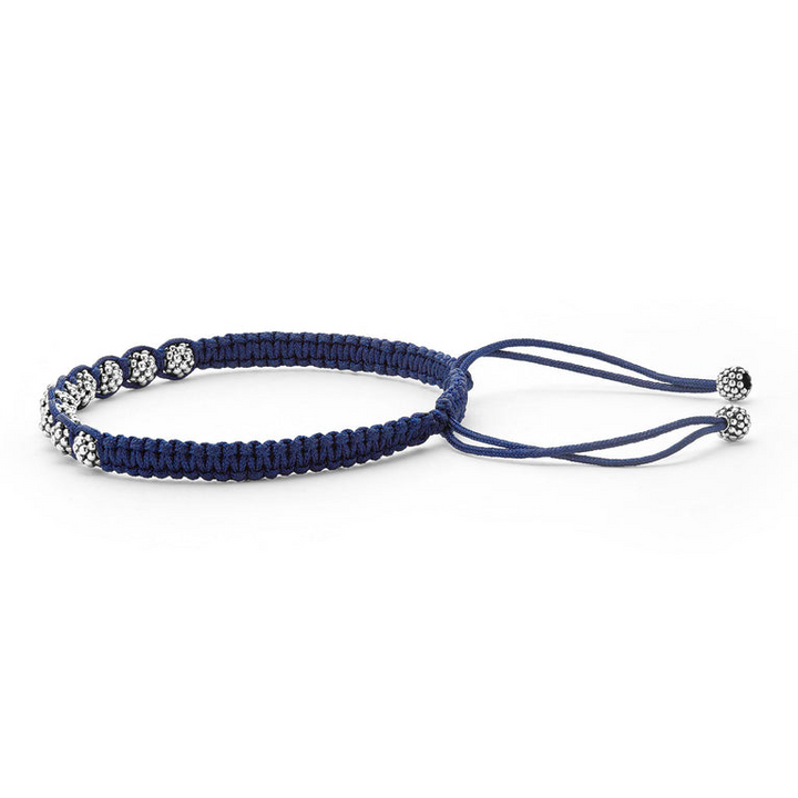 A side-view of a navy blue bracelet in the middle of the white background featuring a braided nylon with sterling silver Caviar beads.