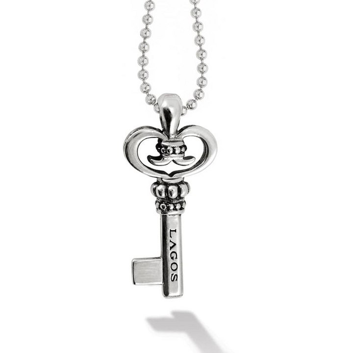 A sterling silver necklace in the middle of the white background focusing on a key pendant