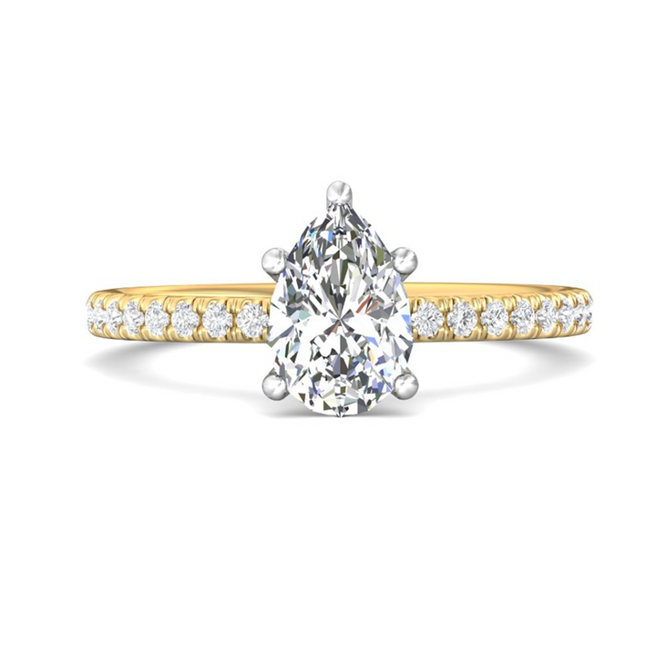 The Half Eternity Engagement Ring, made of yellow gold, lies flat against a white background. It features a pear-cut diamond set in the center with a mircopave diamonds set band