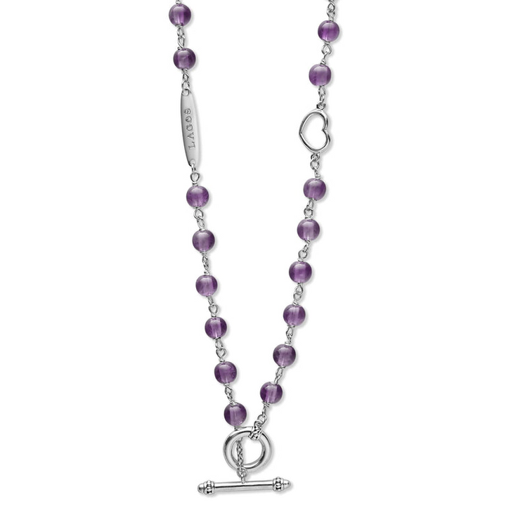 A sterling silver and ceramic beaded necklace in the middle of a white background featuring Amethyst ceramic and silver caviar beading highlights the toggle clasp.