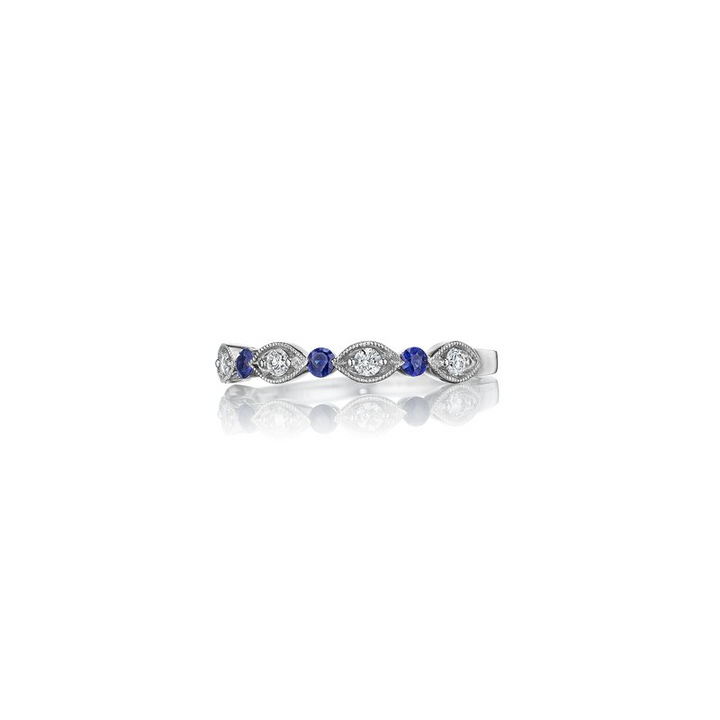 A back view of a white gold wedding band against a white background. The ring features an alternating prong-set round diamonds, surrounded by intricate marquise detailing, and a sapphire round center stone.