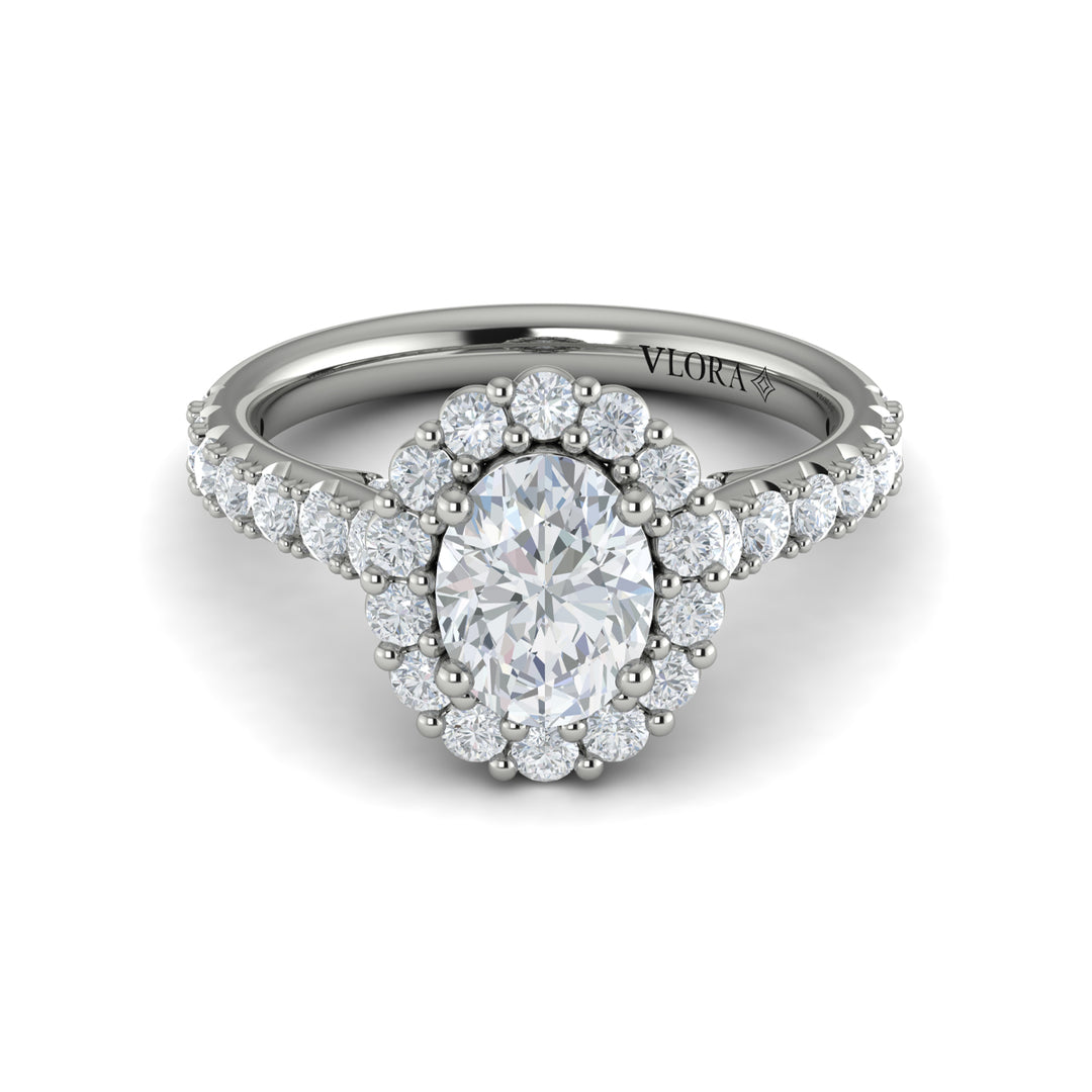 A front view of a white gold engagement ring is set against a white background. The engagement ring features an oval center diamond, a cathedral setting, a diamond-set halo, and a diamond-set band.