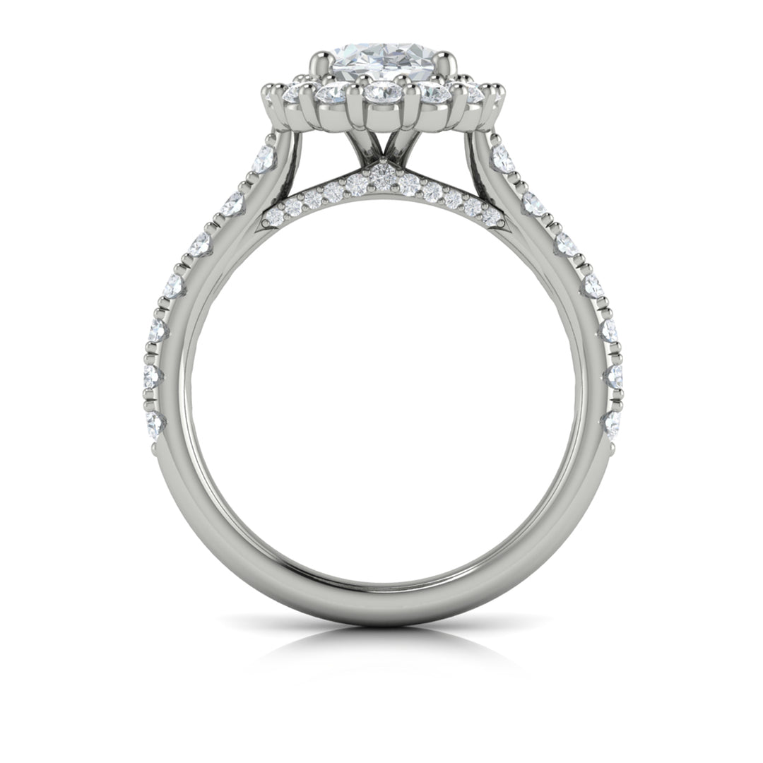 A top view of a white gold engagement ring is set against a white background. The engagement ring features an oval center diamond, a cathedral setting, a diamond-set halo, and a diamond-set band.