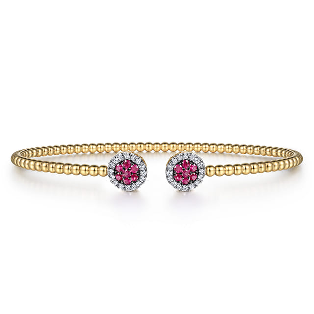 Front view of the Bujukan cuff with two round ruby clusters surrounded by diamond halos on a yellow gold beaded band