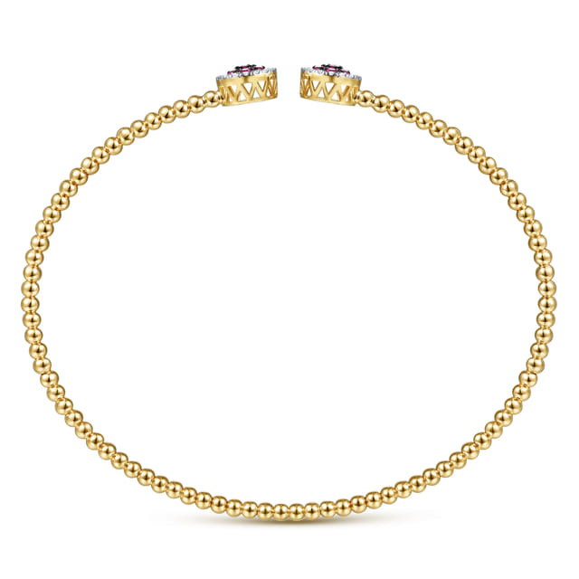 Overhead view of the Bujukan gold cuff showing its beaded band and openwork sides beneath the gemstone caps