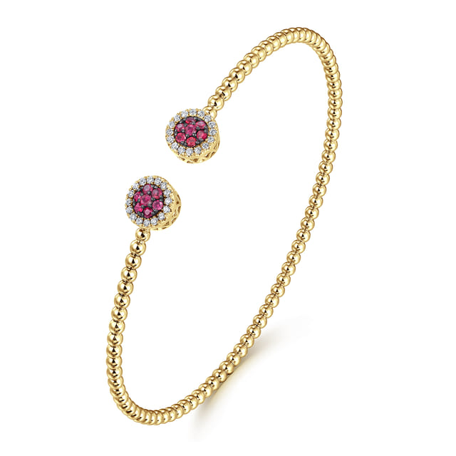 Gabriel & Co Bujukan yellow gold beaded cuff shown at an angle with ruby cluster and diamond halo caps