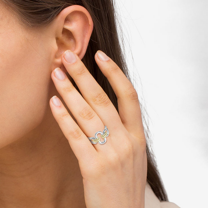 A woman is wearing a sterling silver and 18k gold ring featuring Sterling silver and18k gold variations of Caviar beading and fluting elements