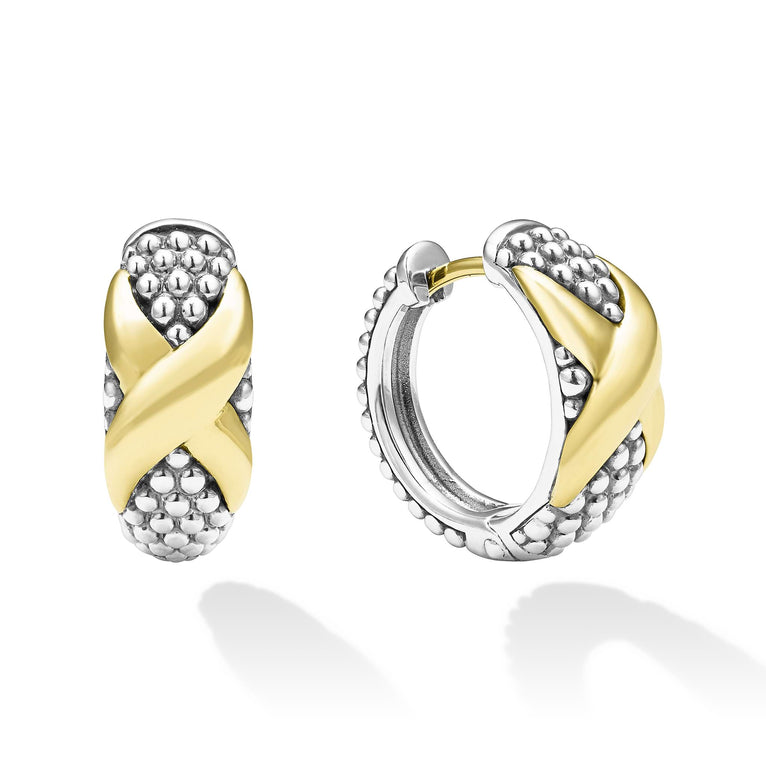 A pair of two-tone huggie earrings with Smooth 18k gold and sterling silver Caviar beading and an x motif. The right earring is angled to the side.