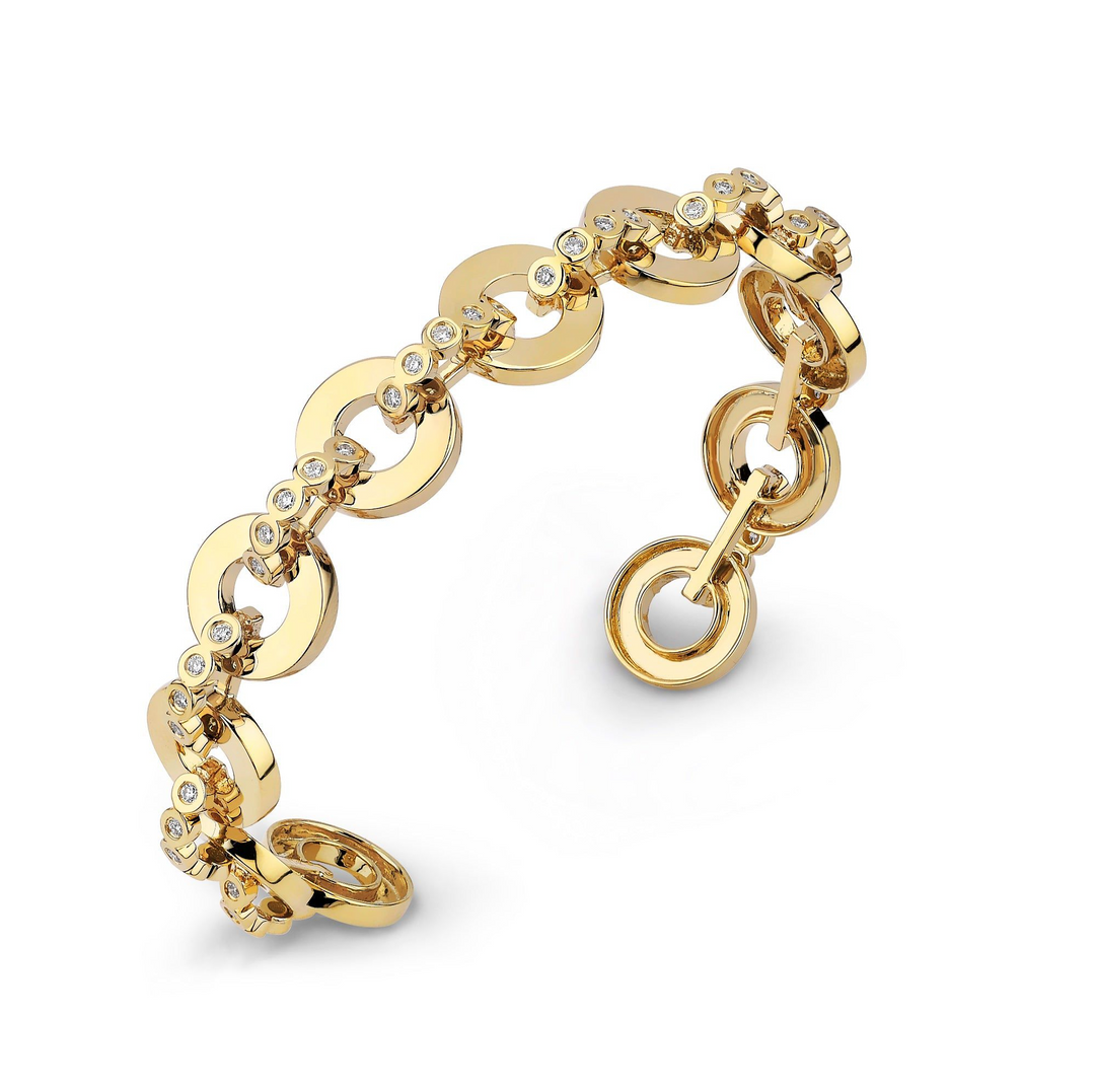 A close-up of a yellow-gold bracelet angled to the right on a white background. The bracelet features bezel-set stones and circle links.