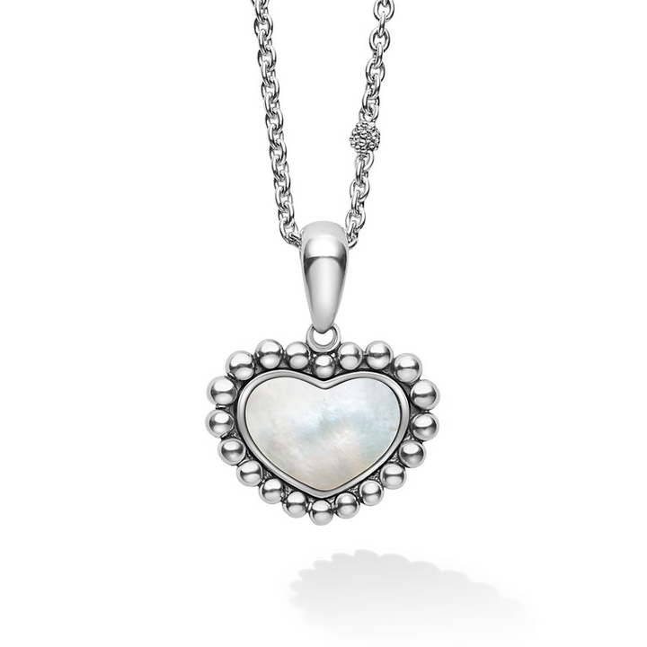 A close-up view of a sterling silver necklace featuring a heart-shaped mother of pearl gemstone pendant framed by sterling silver Caviar beading