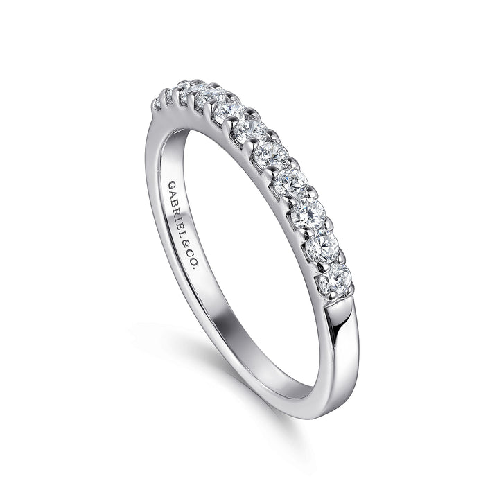 This is a close-up of a white gold ring angled to the right. It shows the inside of the band against a white background. The band features eleven round-cut diamonds in a straight line.