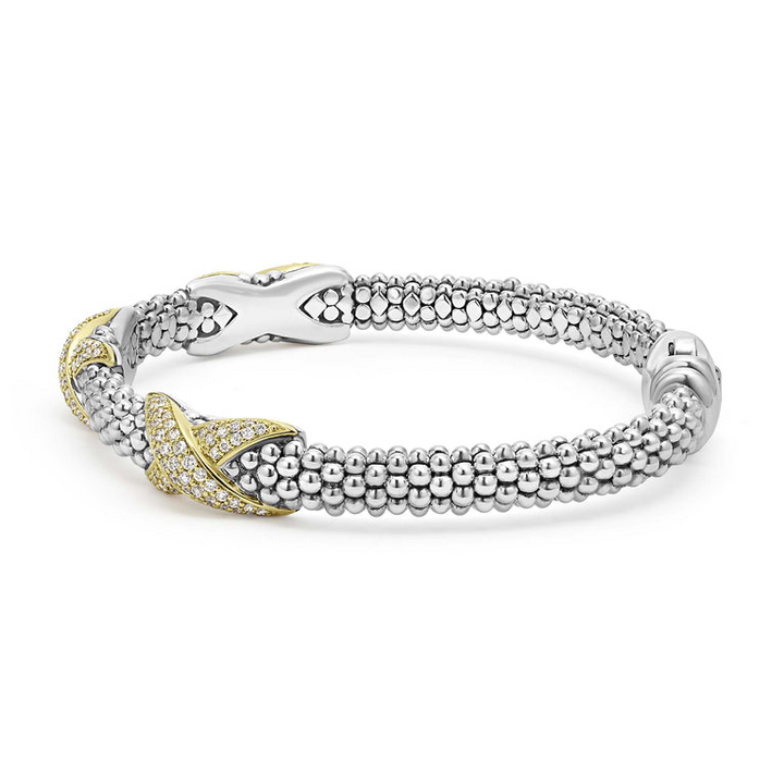 A Sterling Silver & 18k gold bracelet resting in the middle of a white background. The bracelet features diamond-set X stations, caviar beading, and a stainless steel clasp.