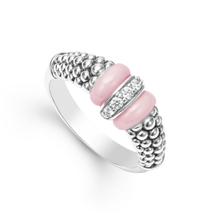 An angled view of a white gold diamond ring against a white background. The ring features round-shaped diamonds set in sterling silver, accented by sleek light pink ceramic and Caviar beading around the band. 