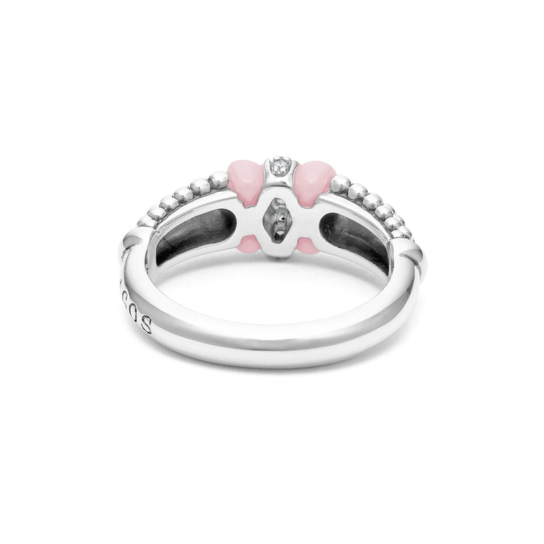 A back view of a white gold diamond ring against a white background. The ring features round-shaped diamonds set in sterling silver, accented by sleek light pink ceramic and Caviar beading around the band. 