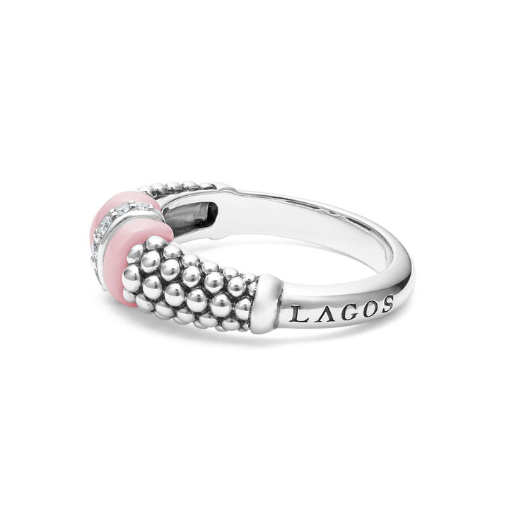 A side view of a white gold diamond ring against a white background. The ring features round-shaped diamonds set in sterling silver, accented by sleek light pink ceramic and Caviar beading around the band. 