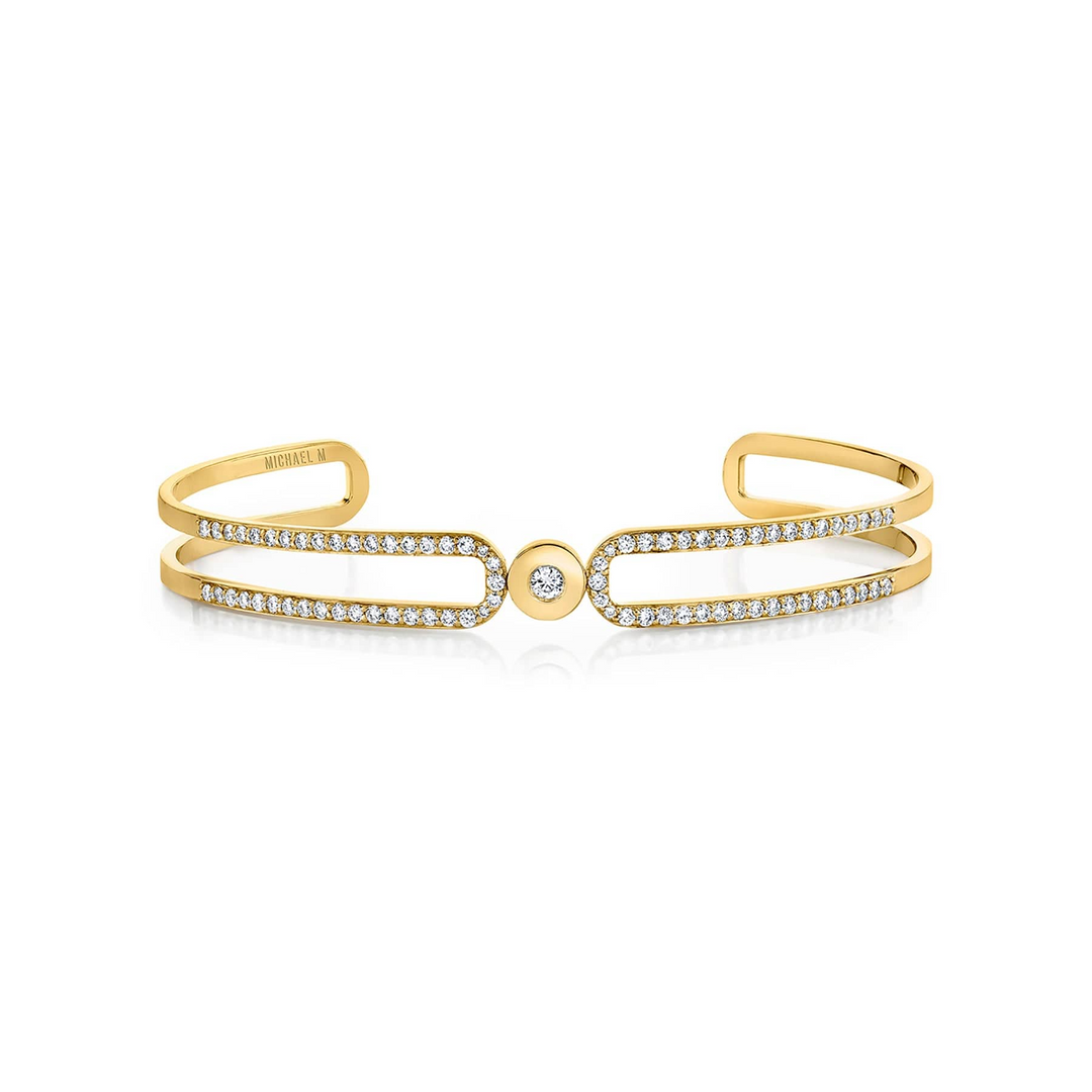 A yellow-gold bracelet lying flat across a white background. The bracelet features a paved double-banded cuff bracelet.