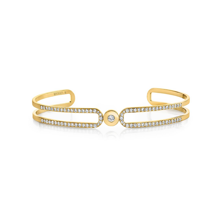 A yellow-gold bracelet lying flat across a white background. The bracelet features a paved double-banded cuff bracelet.