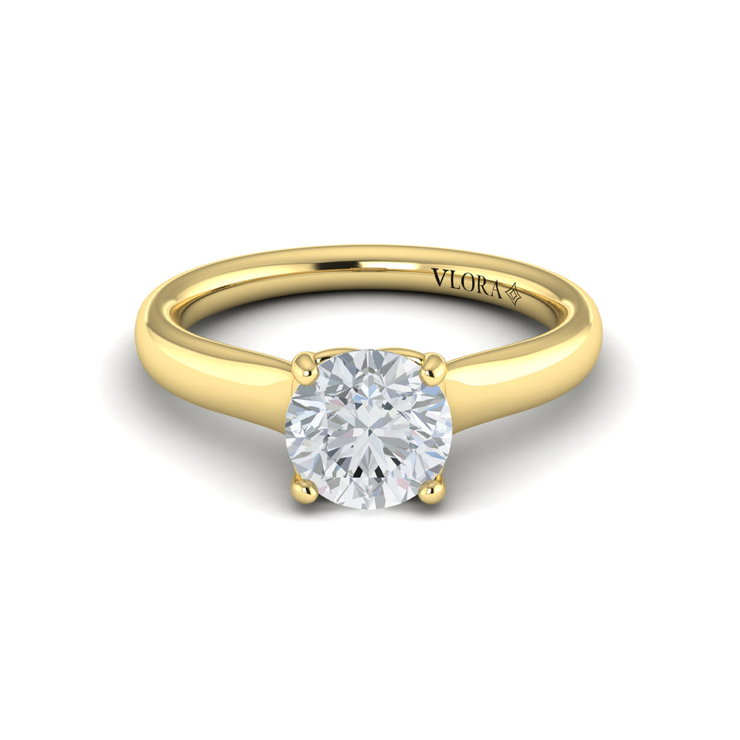 A front view of a yellow gold engagement ring is set against a white background. The engagement ring features a round center diamond, a cathedral setting, and a V-shaped setting.