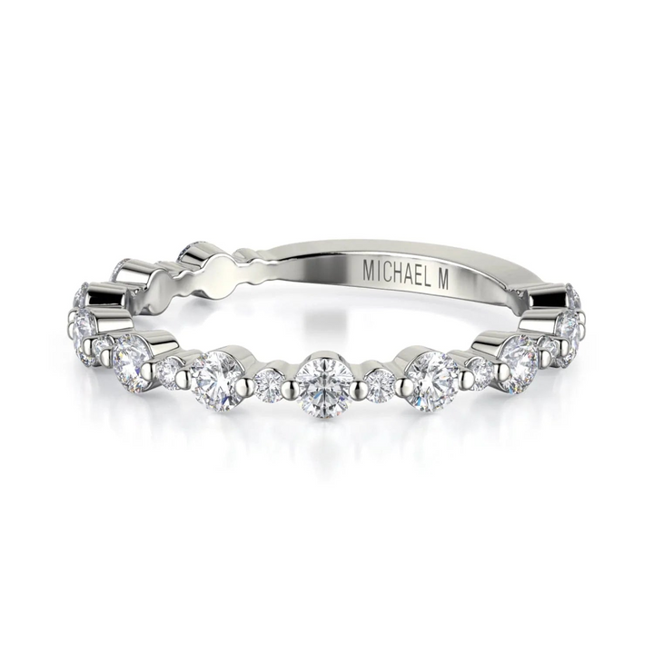 A front view of a white gold wedding band against a white background. The ring features a 3/4 eternity style with alternating sizes of prong-set round-shaped diamonds.