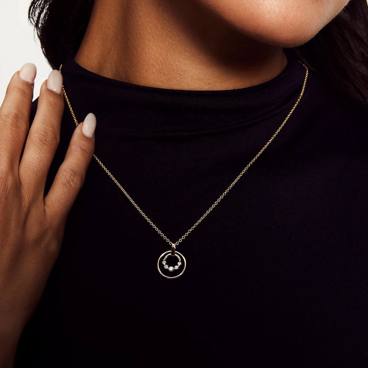 Model wearing the MICHAEL M Cloud Double Ring Pendant Necklace over a black high-neck top